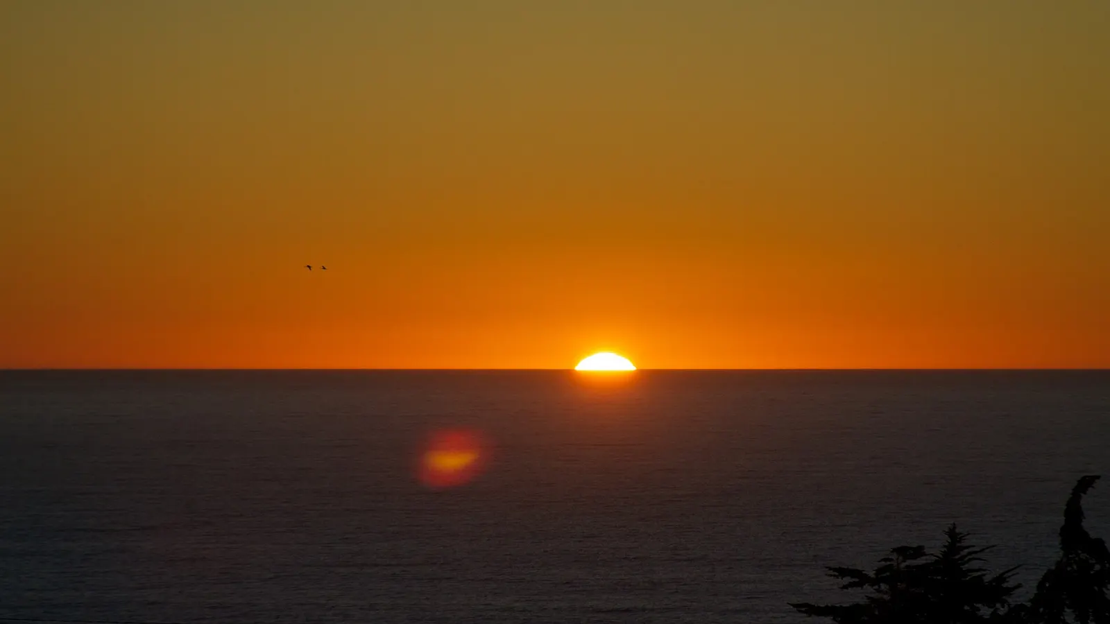 El sol tocando el horizonte del océano Pacífico en Pichilemu