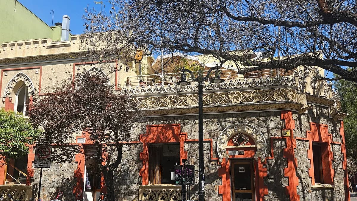 Edificio antiguo de fachada roja y árboles en una calle del barrio Lastarria en Santiago