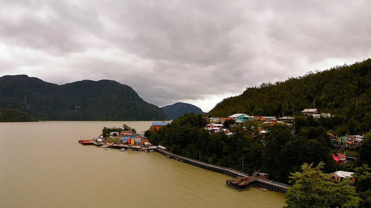 Vista de Caleta Tortel con casas sobre la ladera y pasarelas junto al agua
