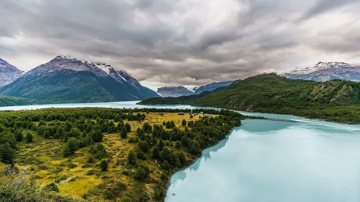 Lago Dickson de aguas celestes rodeado de bosque y montañas en la parte trasera del macizo Paine
