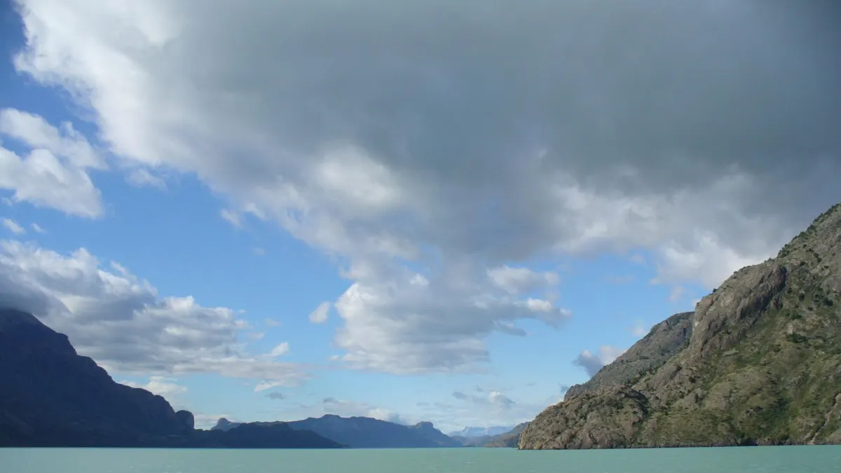 Lago O'Higgins de aguas turquesa entre montañas bajo un cielo con nubes