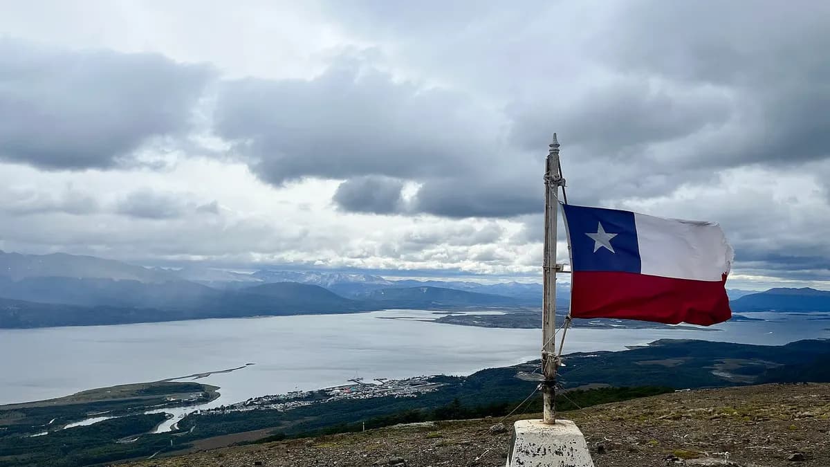 Vista de Puerto Williams y el canal Beagle desde un cerro de la isla Navarino, con la bandera de Chile
