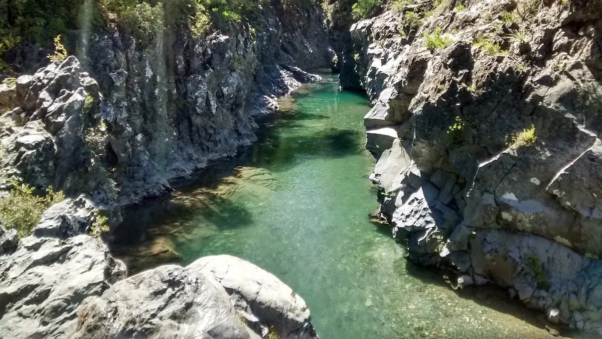 Pozas de agua verde entre paredes de roca basáltica en el río Claro